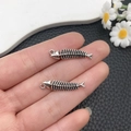 Gros plan de deux pendentifs arêtes de poisson argent antique pour création de bijoux - Forme d'Arête de Poisson (21411)
