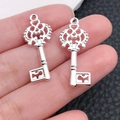 Silver crown-shaped key pendants with heart cutouts held in hand for DIY jewelry making - Bright Silver Crown Hollow Key (20960)