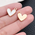 DIY gold and white enamel heart pendants held by hand for jewelry making necklaces - White Enamel Heart Shape (14982)