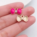 Roze emaille strikhanger met goudkleurige plating en een heldere strassteen in het midden - Strass Strik