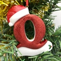 Glittery red Christmas letter Q ornament with Santa hat hanging on a festive tree - Letter Q (Style Q)