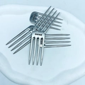 Close-up of four silver cheese markers with Swiss engraving on a clean white tray - SWISS Label