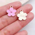 Pink enamel flower charms for DIY jewelry making shown on hand for scale - Pink Five-Petal Bloom (11880)