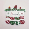 Close-up of resin Christmas fireplace ornament with red candles and four hanging mittens - Snowflake Mitten Family Style (5598143997280)