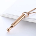Polished rose gold cylinder whistle necklace with elegant box chain on a magazine - Rose Gold Fashion Style