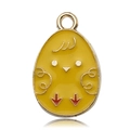 Macro view of egg-shaped yellow enamel chick pendant charm with golden metal details - Ginger Yellow Chick