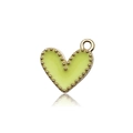 Dettaglio macro di un ciondolo a cuore smaltato verde chiaro con bordi dorati per gioielli - Giallo