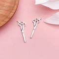 Paar hellsilberne Vintage Scheren-Anhänger für DIY-Schmuck auf rosa Hintergrund - Haarschneidewerkzeug Flachschere (16942)