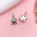 Silver sea turtle pendants showing front and back details on pink background - Sea Turtle (4256)
