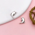 Silver dolphin stud earrings with vintage texture on pink and white background - Antique Silver Alloy Perforated Dolphin Spacer Style (15979)