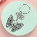 Elegant silver butterfly keychain with honeybee and sunflower charms on a pastel display - Antique Silver Hollow Butterfly Keychain
