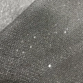 Macro view of grey knit fabric with dense silver sequins and intricate woven texture - Gray