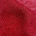 Macro shot of red knit fabric with shimmering sequins and intricate textile textures - Red