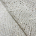 Macro shot of white knitted fabric featuring gold sequins and soft wool texture detail - White