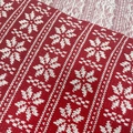 Close-up of Christmas knitted fabric featuring classic red and white snowflake patterns - Red