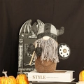 Detalle de gnomo vikingo de peluche con casco, escudo y hacha en escena festiva - Gnomo Caballero Marrón