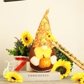 Detail of harvest gnome doll with yellow beard holding orange pumpkin on decorative stand - Yellow Beard