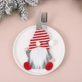 Detalle de porta cubiertos de gnomo navideño con barba larga sobre un plato de cerámica - Rayado