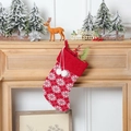 Red knit Christmas stocking with white snowflake patterns and decorative pom poms - Knitted Snowflake Stocking