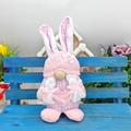 Détail d'un gnome de Pâques rose avec oreilles de lapin sur un tabouret en bois bleu - Lapin Rose