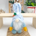 Detail of plush Easter gnome with rabbit ears and orange carrot on rustic wooden shelf - Sky Blue