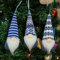 Tre gnomi natalizi blu con cappelli a maglia appesi a un ramo di albero festivo - Stile Blu (B)