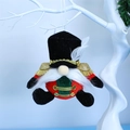 Detail of Nutcracker gnome plush hanging ornament with red and green uniform on white branch - 18x15x8cm / Red Soldier Hanging Decor