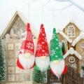 Close-up of three knitted Christmas gnome ornaments hanging on a white branch - Snowflake Knit Red Green White Style (F)