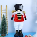 Close-up of a festive Christmas Nutcracker Gnome with a red suit and feather hat decoration - Large Standing Cyan Soldier