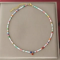 Handgefertigte bunte Perlenkette mit rotem Herzanhänger und goldener Metallkette - Rotes Herz