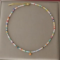 Bunte Boho-Perlenkette mit orangem Emaille-Herzanhänger und goldener Verlängerungskette - Orange Herz