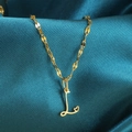 Detail van gouden ketting met letter L-hanger en hartje op donkerblauwe zijde - Goud-L