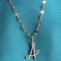 Minimalistische zilveren hartketting met cursieve letter A-hanger op blauwe zijden achtergrond - Staal-A