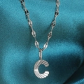 Silver-colored alphabet C pendant necklace with radial texture on blue silk background - Letter C / Silver