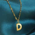 Gouden ketting met letter D hanger en radiale textuur op een zijden achtergrond - Goud-D