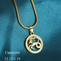 Golden Capricorn zodiac pendant necklace with white crystals on blue silk background - Capricorn