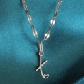 Zilveren halsketting met letter K hart hanger op een blauwe satijnen achtergrond - Staal-X