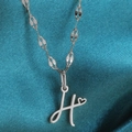 Zilverkleurige hartjesketting met een gestileerde letter H hanger en glanzende schakels - Staal-H