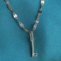 Zilveren hart-sleutelketting met paillettenketting op een donkerblauwe stoffen achtergrond - Staal-I