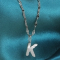Silver stainless steel necklace with textured letter K pendant on satin backdrop - Letter K / Silver