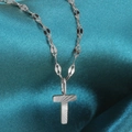 Silver necklace featuring a T-shaped pendant with radial texture on a silk background - Letter T / Silver