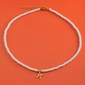 Pearl necklace with a golden letter H heart pendant on a vibrant orange background - Letter H (NK228ZP39270-2)