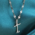 Minimalistische zilveren hartketting met letter T hanger op een blauwe zijden stof - Staal-T