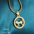 Golden Taurus zodiac pendant necklace with white crystals on a premium teal satin background - Taurus