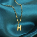 Gouden roestvrijstalen ketting met letter H-hanger op donkerblauwe zijden stof - Goud-H