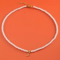 White pearl necklace with gold letter L heart pendant and lobster clasp on orange background - Letter S (NK228ZP39270-2)