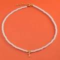 Gold plated pearl necklace with letter T heart pendant on a vibrant orange background - Letter T (NK228ZP39270-2)