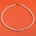 White pearl necklace featuring a gold letter U pendant with small heart detail - Letter U (NK228ZP39270-2)