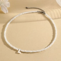 Macro shot of white faceted bead necklace with an uppercase L letter pendant detail - L (SHNK2434)