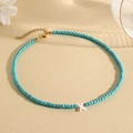 Detail of turquoise bead necklace featuring a white shell letter X pendant and gold clasp - X (SHNK2435)